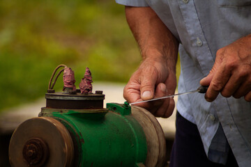 Men's hands, in the summer in the country, on a grinding machine sharpen a knife. Banner, cover, flyer, layout design
