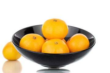 Several ripe organic tangerines in a ceramic plate, close-up, isolated on white.