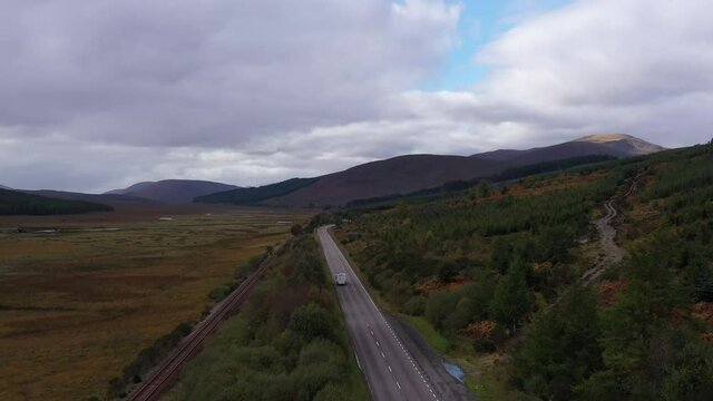 aerial drone footage of strath bran in the north west torridon region of the scottish highlands near kinlochewe and achnasheen showing the road and rail track winding through the landscape