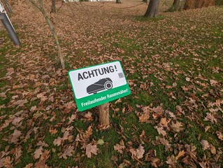 Achtung Schild für Rasenmäher im Herbst