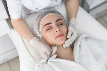 Fototapeta na wymiar Face Skin Care. Close-up Of Woman Getting Facial Hydro Microdermabrasion Peeling Treatment At Cosmetic Beauty Spa Clinic. Hydra Vacuum Cleaner. Exfoliation, Rejuvenation And Hydratation. Cosmetology.