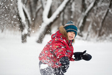 Fototapeta na wymiar Boy walking in a snowy winter forest