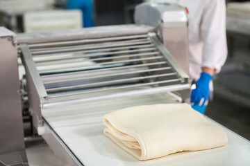 Raw puff pastry on the conveyor before freezing. Semi-finished products.