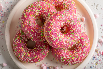 Sweet and homemade pink donuts with glaze and sprinkles