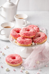 Popular and fresh pink donuts and coffee as best dessert.