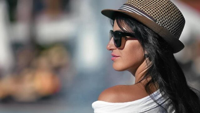 Closeup lady wearing straw hat and sunglasses relaxing near natural waterfall at luxury spa resort