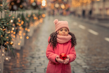 African American girl 5 years walks the streets in anticipation of the New Year holiday