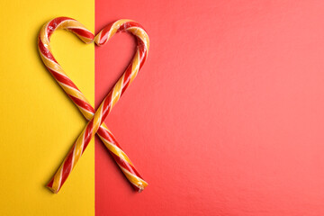 A heart symbol made of Christmas candies on a yellow-red background