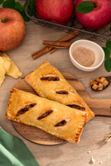 Naklejka na ściany i meble Baked apple hand pie in wooden background