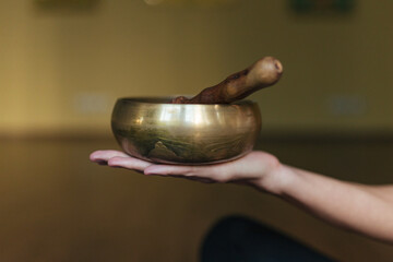 Close-up hands of a woman playing on singing bowls. Relaxation and meditation. Tibetan singing bowls. 