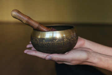 Close-up hands of a woman playing on singing bowls. Relaxation and meditation. Tibetan singing bowls. 