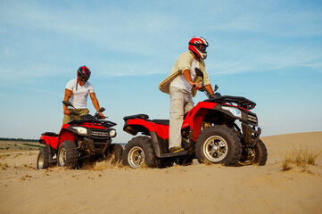 Man in helmet rides on atv in desert sands © Nomad_Soul