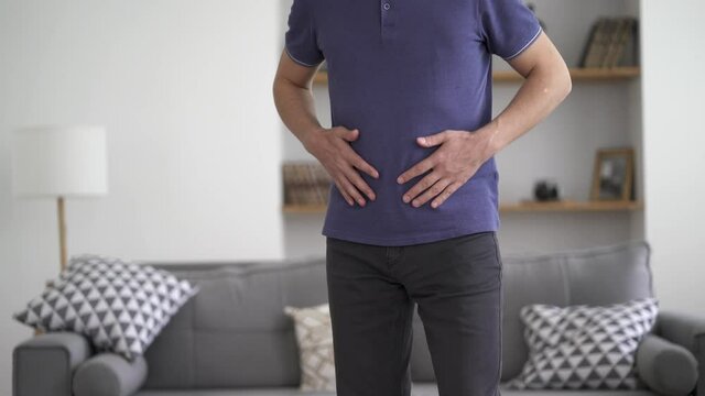 Stomach ache, man with abdominal pain suffering at home, health problems concept