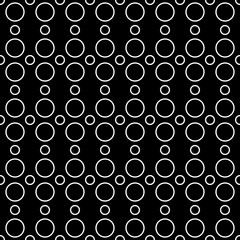 Rings of white color that are repeated and a black background. Vector seamless pattern with rings.