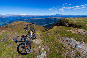 Fototapeta na wymiar A black mountainbike parked on the mountain summit in the Dolomites in South Tyrol