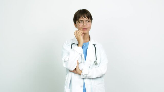 Young woman with nurse uniform standing and thinking an idea pointing the finger up over isolated background