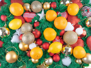 Fototapeta na wymiar Christmas background with a green tree, red and gold balls, oranges and lemons. Merry Christmas and vitamins greeting card concept