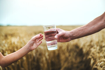 Father and child with a glass of water. Selective focus.