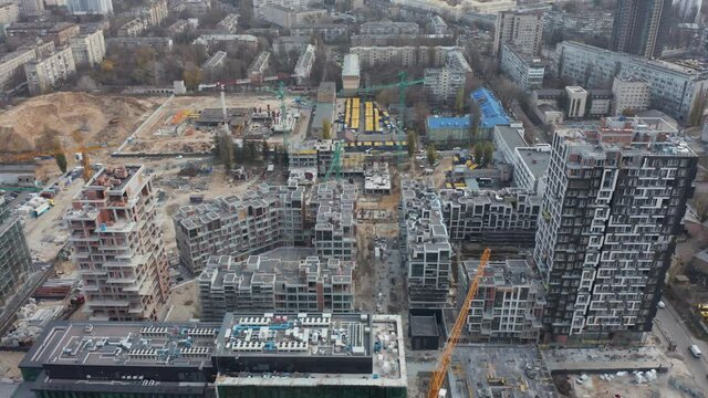 High crane works on building site with a house. Urban Construction Site, Aerial View. Construction area, building area, site area from above. New appartments getting built