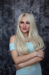 Fototapeta premium Portrait of beautiful young woman with long curly blonde hair 