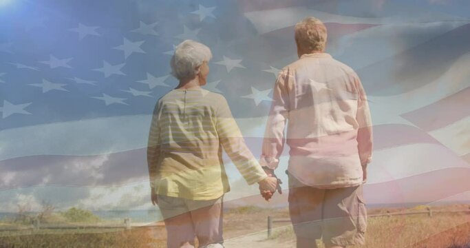 Animation of senior caucasian couple holding hands on beach over flag of united states of america