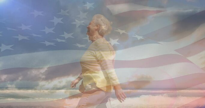 Animation of happy senior caucasian couple walking on beach over flag of united states of america