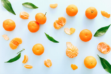 Fresh clementines with leaves on blue background, top view