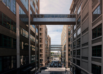 Fototapeta premium Pedestrian Metal Bridge City building. Sky bridge between two buildings between glass building and traditional building. Perspective with worm eyes views, cloudy blue sky.