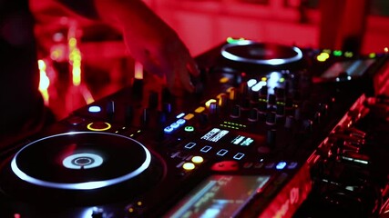 Party dj plays techno music on rave party in club. Disc jockey performing in nightclub. Disk jokey mixing musical tracks with audio mixer