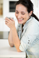 woman at home enjoying a hot drink