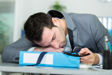 tired businessman sleeping on office desk