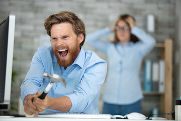 furious man bearded guy office swing hammer on computer