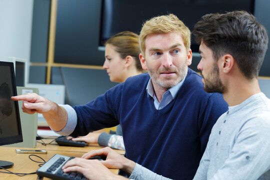 teacher helping student in computer class