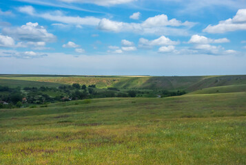 landscape with field, sky and white clouds