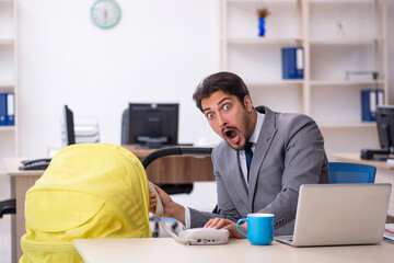 Young male employee looking after new born at workplace