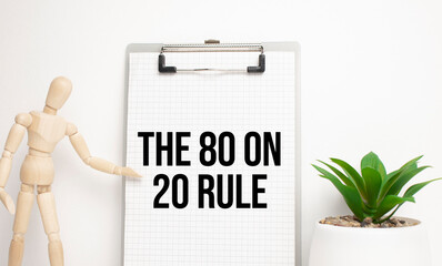 Wooden man shows with a hand to white board with text The 80 on 20 Rule