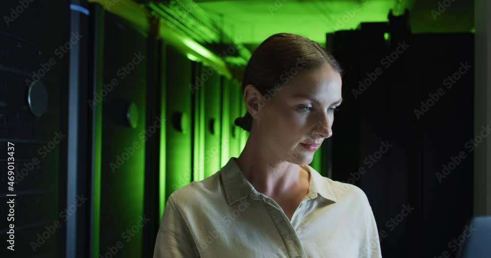 Poster smiling caucasian female it technician using laptop checking computer server
