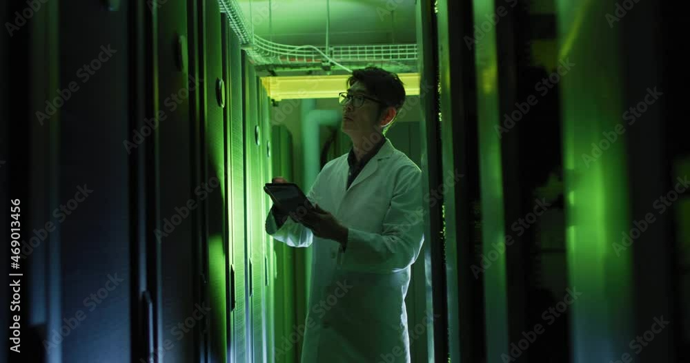 Poster asian male it technician in lab coat using tablet checking computer server