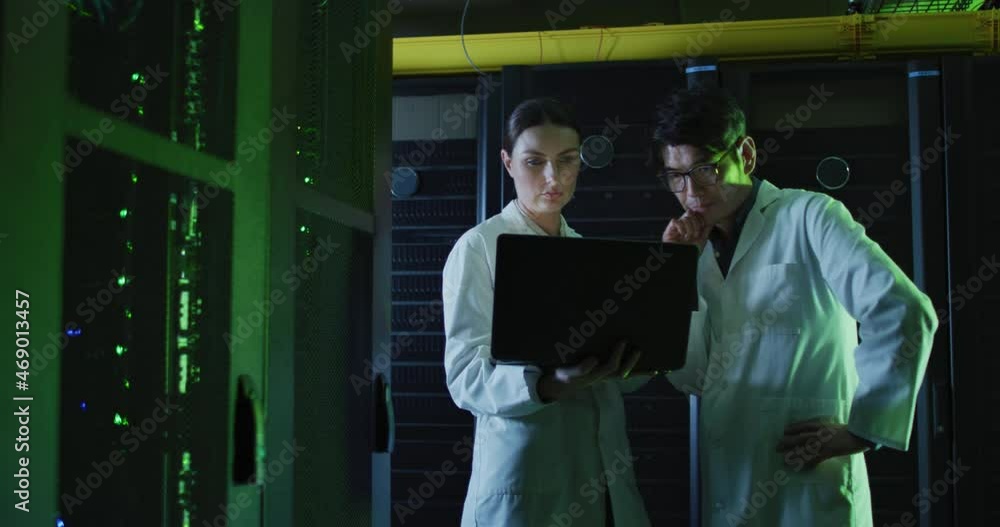 Poster diverse female and male it technicians in lab coats using laptop checking computer server