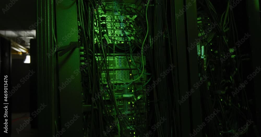 Poster green control lights and multiple cables on computer servers in tech room