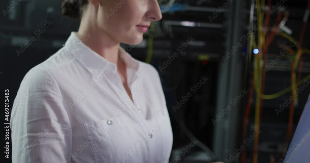 Poster caucasian female it technician using laptop and checking computer server
