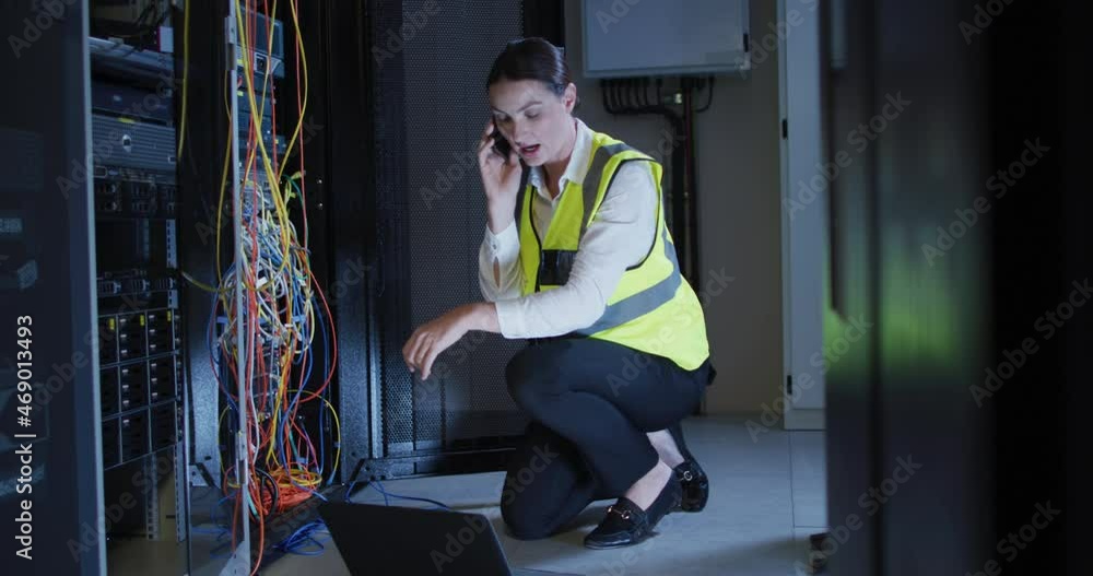 Poster caucasian female it technician using smartphone and laptop checking computer server