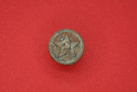 one old brown soviet button with star on red background