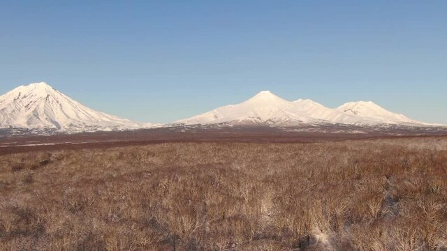 4K Aerial footage of three famous volcanoes in Kamchatka, Russia. Cones of Koryaksky volcano, Avachinsky volcano and Kozelskiy volcano. Kamchatka nature in winter.