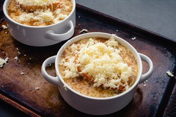 Bowls of French Onion Soup With Toasted Bread and Grated Cheese: Bowls of French onion soup on a sheet pan