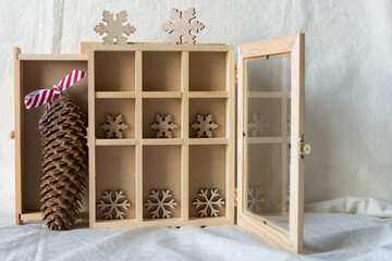 christmas themed background - open box with pine cone and wooden snowflakes