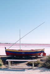 Traditional boat at the Salt fields of Salin de Giraud, France. Abstract and minimalistic landscape. Pink sugar cotton candy color