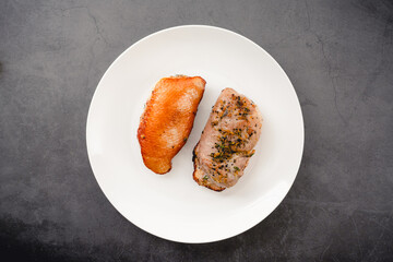 Overhead View of Cooked Duck Breasts: Cooked spice-rubbed duck breasts on a white plate