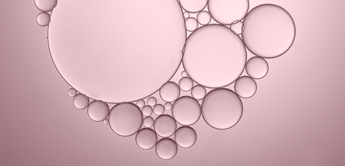 Oil droplets to surface of water to produce a different sized bubbles which have been highlighted by the effects of rose pink background.