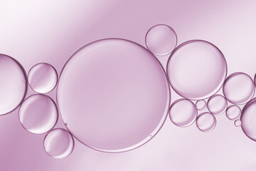 Art image of oil and water bubbles on pink-purple background.